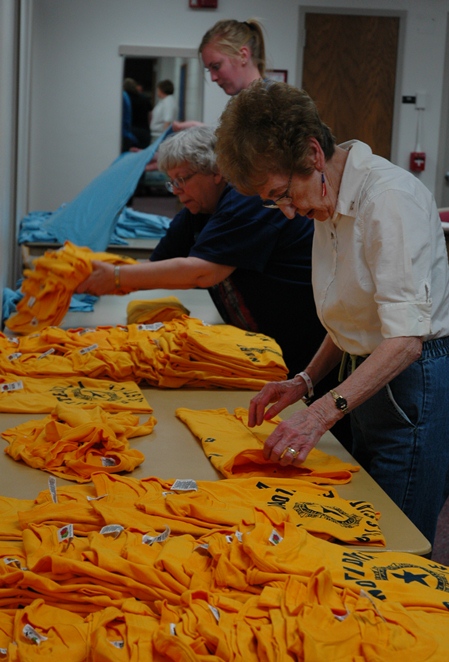 Auxiliary staff fold tshirts in preparation for sale